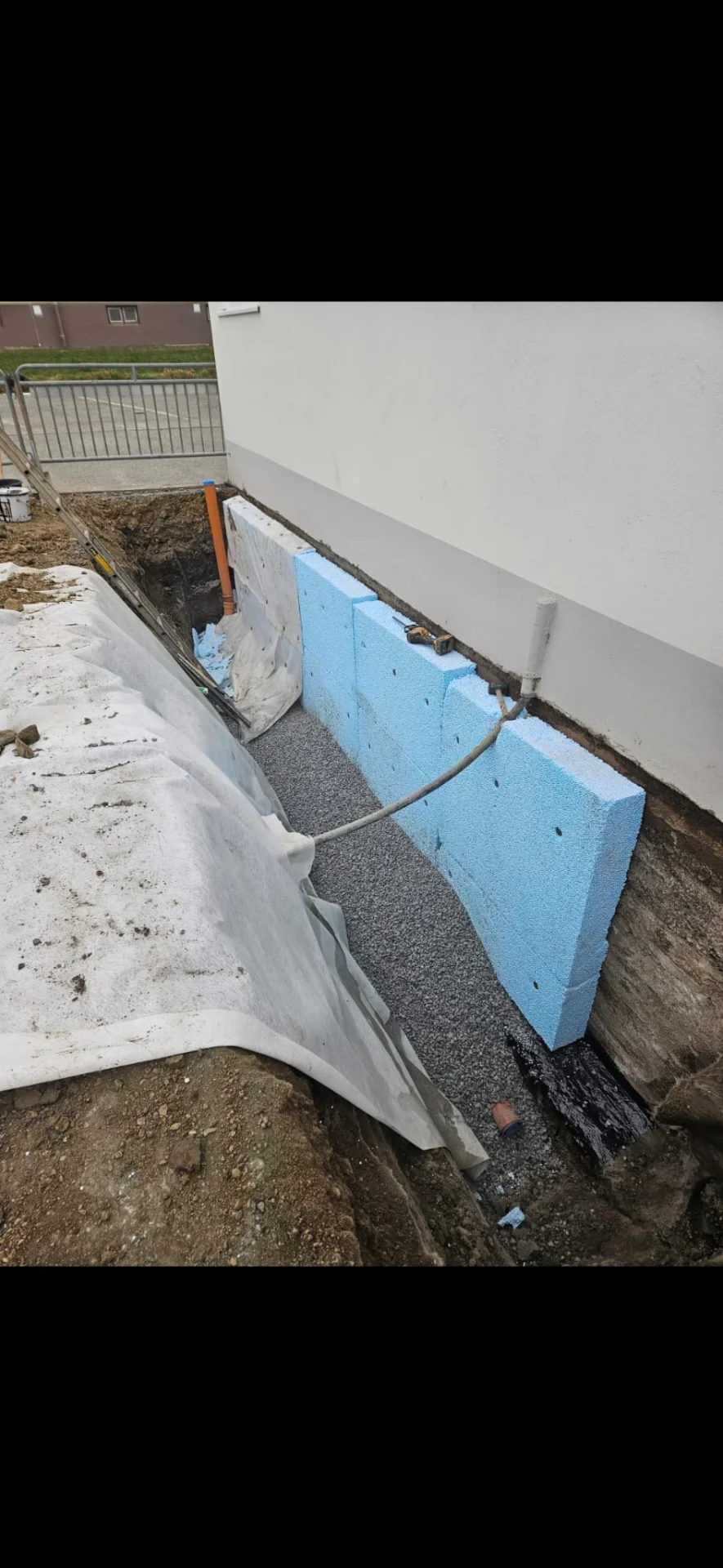 Dränering av husgrund i Frölunda - arbetare gräver och installerar dräneringssystem